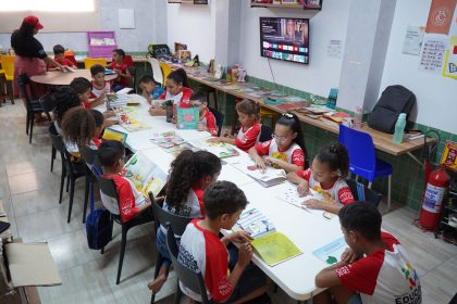 Crianças leem livros em uma biblioteca comunitária no Brasil