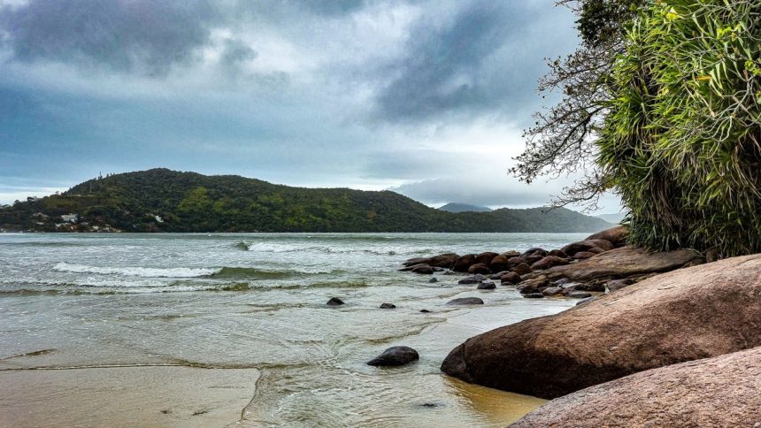 Vista da Praia da Enseada, em Ubatuba, com águas tranquilas e morros cobertos de vegetação